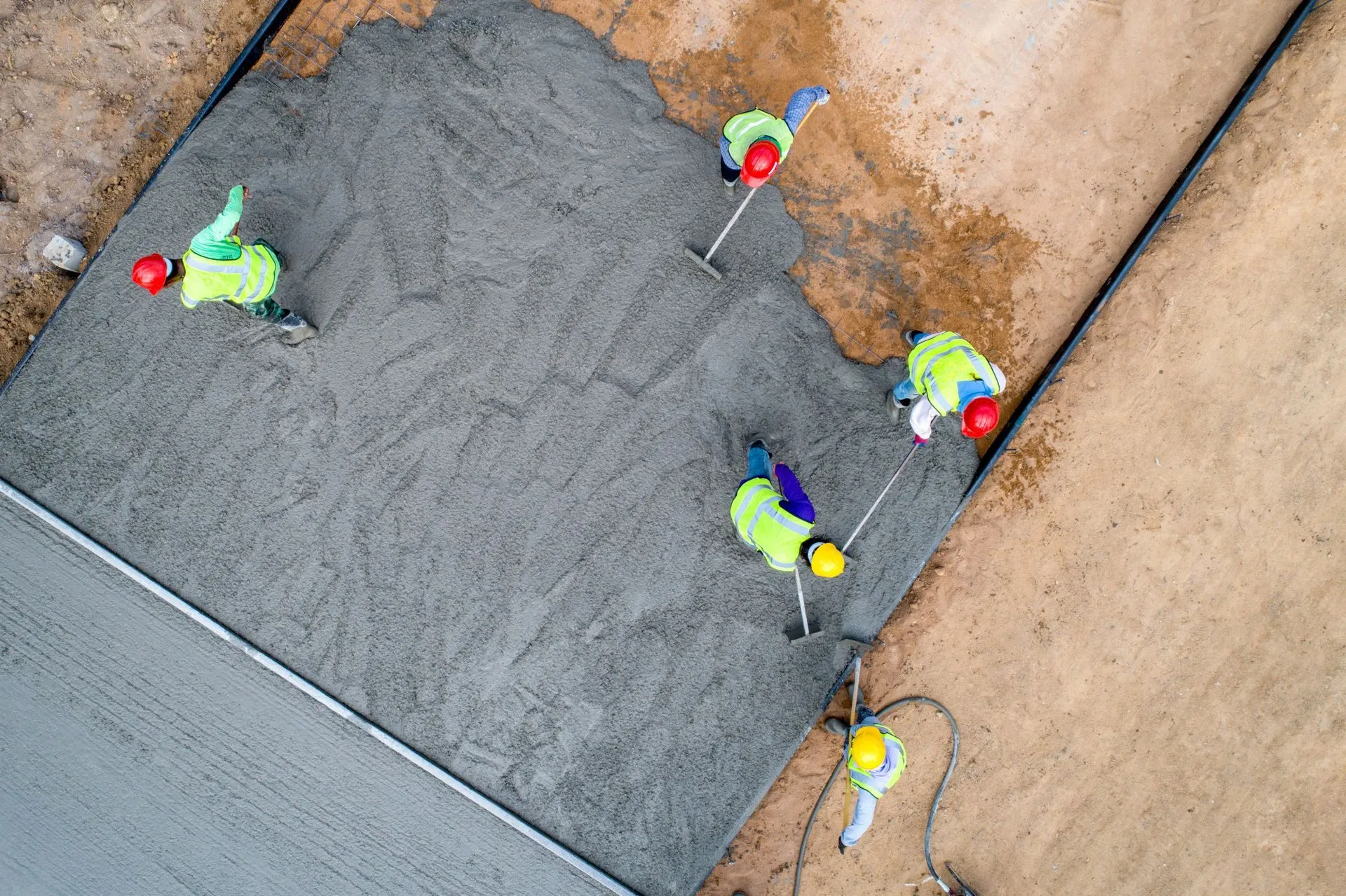 Aerial view of construction workers laying concrete